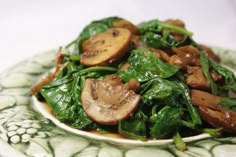 a plate with spinach and mushrooms on it