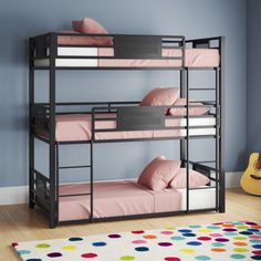 bunk beds with pink sheets and pillows in a blue walled children's bedroom area