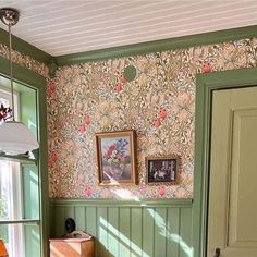 a room with green walls and floral wallpaper