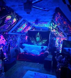 a room filled with lots of colorful lights and decorations on the walls, including a bed covered in blankets