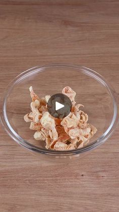 a glass bowl filled with cereal on top of a wooden table