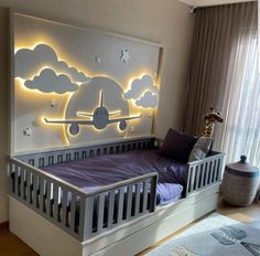 a child's room with a bed, night stand and wall decoration in the shape of an airplane