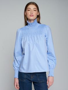 This blue shirt features a fun neckline and is great with pants or jeans. By Vilagallo. Pair it with a Carrie Dunham bag for a complete outfit! Blue Blouse With Ruffled Collar For Daywear, Blue Cotton Blouse For Fall, Light Blue Blouse For Fall Workwear, Trendy Light Blue Blouse For Work, Trendy Light Blue Blouse For Workwear, Blue Cotton Tops With Ruffled Collar, Blue Fitted Top With Ruffled Collar, Elegant Blue Top With Ruffled Collar, Blue Collar Blouse For Spring