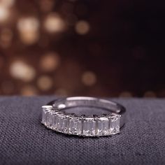 a diamond ring sitting on top of a piece of cloth with blurry lights in the background