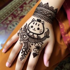 a woman's hand with henna tattoos and a cat design on the palm