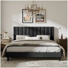 a bedroom with a bed, chandelier and two pictures on the wall above it