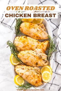 oven roasted chicken breast with lemons and rosemary garnish in a white dish