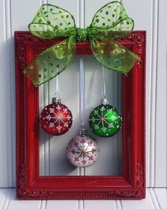 christmas ornaments are hanging in a red frame with green bow on it's head