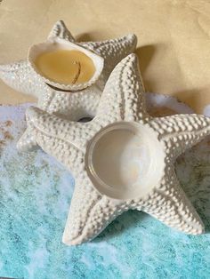 two starfish shaped tea cups sitting on top of a blue and white place mat