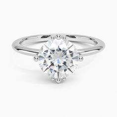 a round brilliant cut diamond engagement ring on a white background, with the center stone setting in