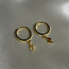 Wonderful Package: You'll Get 1 Pair Gold Lightning Bolt Earrings In A Wonderful Small Box.Easy Storage And Ready To Be Given As A Gift. Length & Size: 11mm Hoop With 3mm*12mm Lightning Dangle Charm.(Warm Tip : If The Ear Post Cannot Clip In,Pls Adjust The Ear Post Up Slightly To Make It Work.) Quality Material: Comes In 14k-Gold-Plated-Brass With A Shiny Lifetime Protective Finish. Tarnish-Resistant Then Can't Be Faded In A Long Time.Nickel Free, Lead Free And Hypoallergenic,Safe To Wear On You Trendy Pierced Huggie Earrings As A Gift, Trendy Huggie Earrings As A Gift, Trendy Dangle Huggie Earrings, Trendy Huggie Earrings With Ear Wire, Trendy Adjustable Gold Cartilage Earrings, Trendy Adjustable Dangle Cartilage Earrings, Trendy Adjustable Drop Cartilage Earrings, Trendy Adjustable Dangle Hoop Earrings, Trendy Adjustable Hoop Jewelry