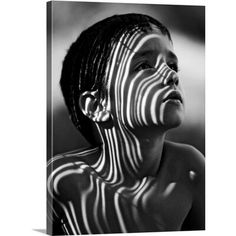 a young boy with his face painted like the zebra stripes on his chest and neck