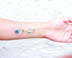 a person's arm with a flower tattoo on the left side of their arm