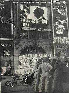 an old black and white photo of people standing in front of a building with signs on it