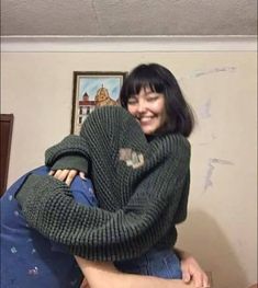 a man and woman hugging each other in the living room