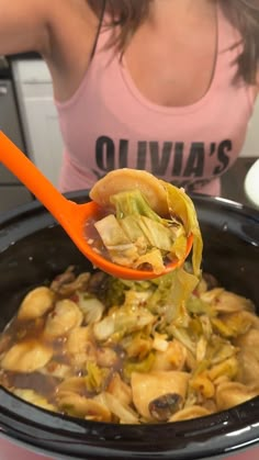 a woman scooping food out of a slow cooker with an orange ladle