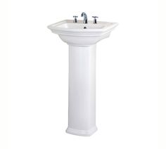 a white pedestal sink with two faucets