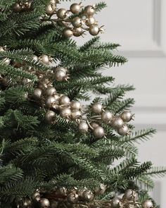 a close up of a christmas tree with ornaments on it's branches and pine cones