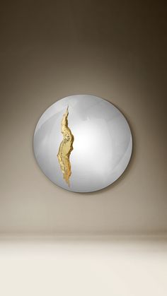 a white and gold plate with a golden piece of food in it's center