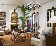 a living room filled with lots of furniture and a chandelier hanging from the ceiling