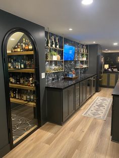 a bar with lots of liquor bottles on the shelves and an arched doorway leading to another room