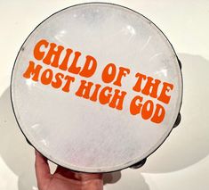 a person holding up a plate with the words child of the most high god on it