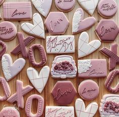 many decorated cookies are arranged on a wooden table with the words love spelled in cursive writing