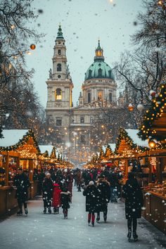 people are walking down the street in front of christmas trees and buildings with lights on them