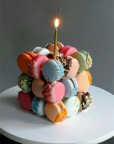 a cake with a lit candle on top of it and lots of candies in the middle