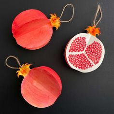 two paper pomegranates with hearts on them