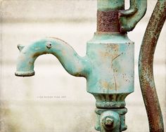 an old rusted water faucet with a hose attached to it