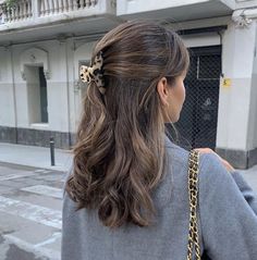 a woman with long hair and a leopard print bow in her hair is walking down the street