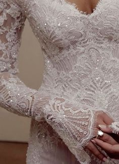 a close up of a person wearing a wedding dress and holding an object in their hand