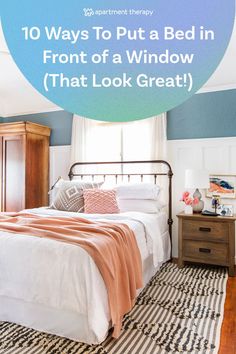 a bedroom with blue walls and white bedding that says 10 ways to put a bed in front of a window that look great