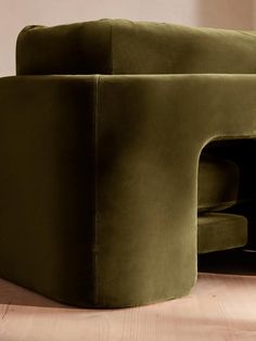 a green couch sitting on top of a wooden floor