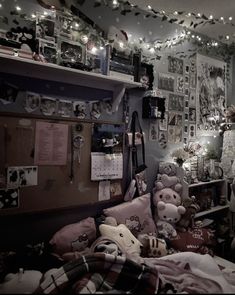 a bedroom with lots of stuffed animals on the bed and lights strung from the ceiling