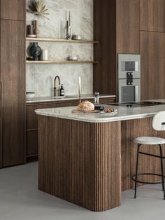 a modern kitchen with an island counter and stools in the center, along with wooden cabinets