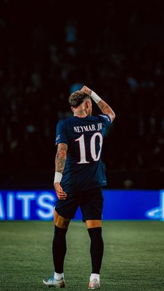 a man standing on top of a soccer field holding his head in one hand and looking down at the ground