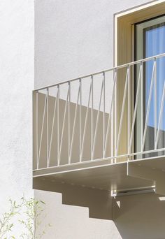 a balcony with a white railing next to a window