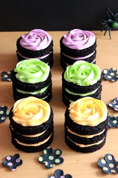 there are many cupcakes that have been decorated with icing and flowers on the table