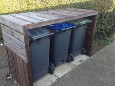 three trash cans are sitting in a wooden box