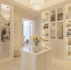 a white closet filled with lots of clothes and flowers