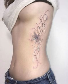 a woman's lower back tattoo with flowers on her stomach and the bottom part of her body