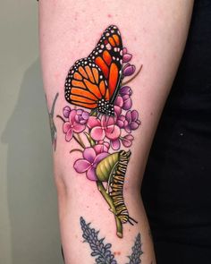 a woman's arm with a butterfly and flowers tattoo on the left side of her body