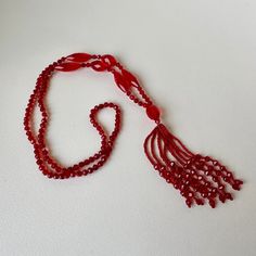 Beautiful, shimmering ruby red glass (likely crystal) beaded sautoir necklace. Art Deco era. A sautoir is a French term for a long necklace that suspends a tassel or other ornament. This amazing vintage collectible will add drama to a dress, tunic or even a t-shirt & jeans. In excellent vintage condition. No chips or imperfections. Necklace approximately 38" long, tassel is 4" long. Elegant Red Long Necklace With Round Beads, Vintage Red Necklace For Celebration, Red Vintage Necklace For Celebration, Elegant Handmade Red Long Necklace, Elegant Red Long Necklace, Handmade Red Necklace For Evening, Elegant Red Long Necklace For Gift, Vintage Lariat Beaded Necklace Gift, Vintage Lariat Beaded Necklaces For Gifts