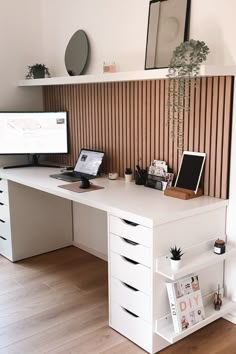 a white desk with two computers on it