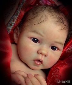 a close up of a baby wearing a red dress