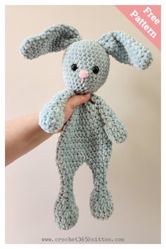 a crocheted blue bunny stuffed animal in someone's hand