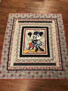 a mickey mouse quilt on the floor