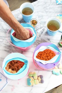 three bowls with food in them sitting on a table next to cups and spoons